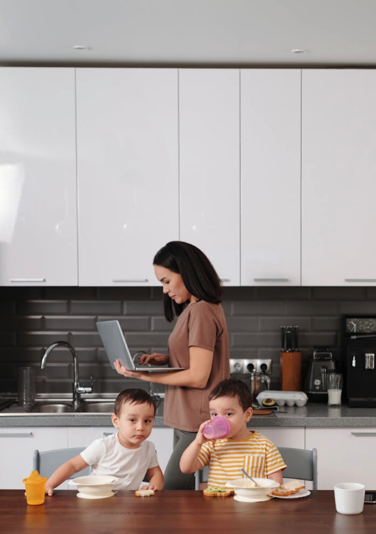 A confident woman smiling while working on a laptop at home, symbolising a successful return to work after a career break